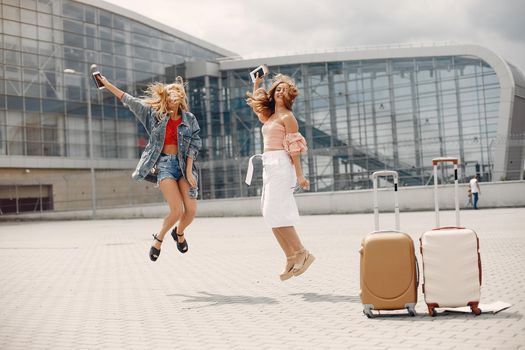 Girls at the airport. Friends with suitcasess