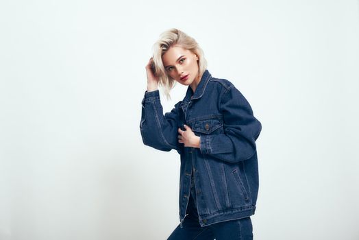 Always in style. Cute young woman in jeans wear looking aside while standing against grey background in studio. Denim. Fashion concept. Beauty