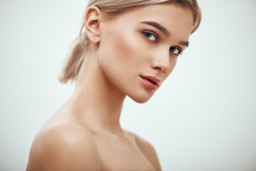 Feeling beautiful. Gorgeous young blonde woman with perfect skin looking at camera while standing against grey background. Skin care. Beauty concept