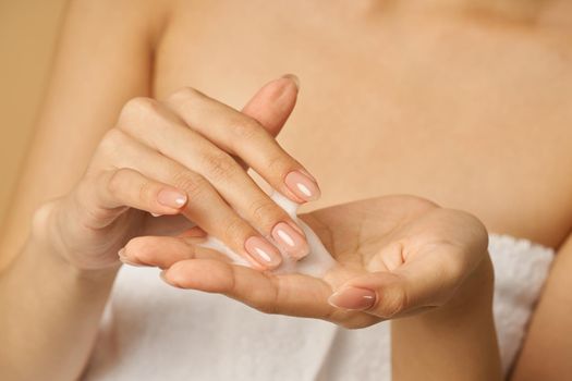 Close up of hands of woman preparing to apply gentle foam facial cleanser. Beauty products and skin care concept