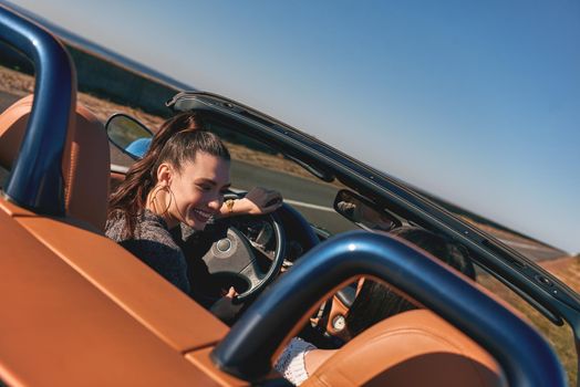 Two happy friends in the cabriolet driving everywhere and looking for freedom and fun