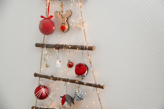 Handmade wooden Christmas tree with toys hanging on the wall