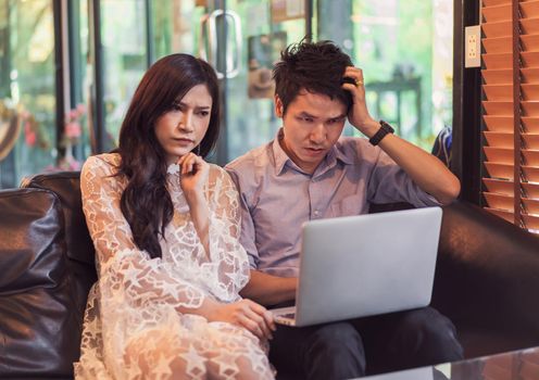 stressed man and woman using laptop in a cafe