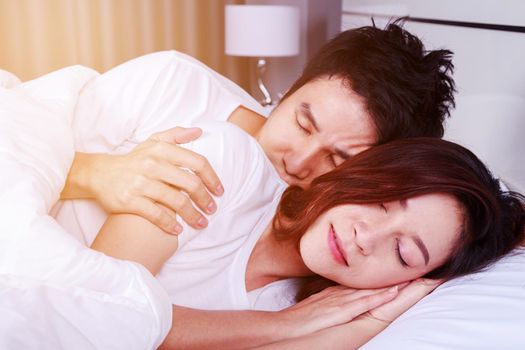 young couple hugging and sleeping on bed in the bedroom