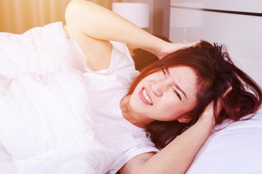 woman having sleepless on bed and having migraine,stress, insomnia, hangover in the bedroom