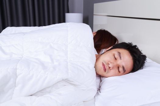 sick young man sleeping on bed with his wife