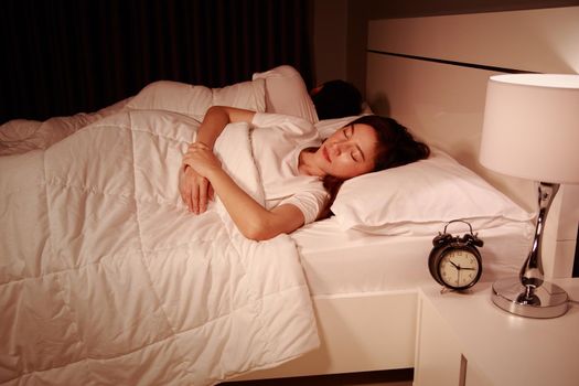 young couple sleeping on a comfortable bed in bedroom at night