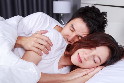 young couple hugging and sleeping on bed in the bedroom