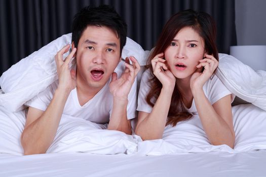 young couple watching scared movie on bed in the bedroom