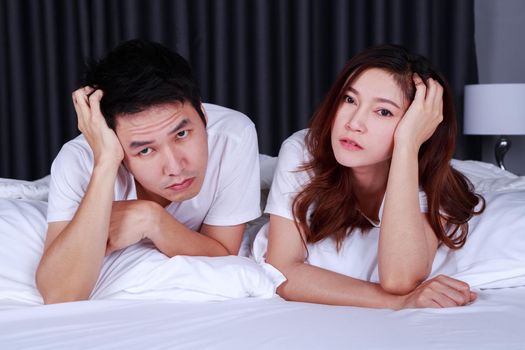 young depressed couple on bed in the bedroom