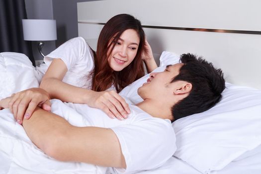 young lovely couple lying in a bed and looking to each other (eyes to eyes)