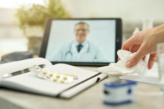 Selective focus of hand grabbing tissues from the table with medical notes and equipment