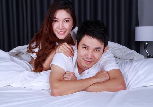 happy young attractive couple hugging on bed in the bedroom