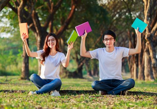 couple holding a book and resting in the park