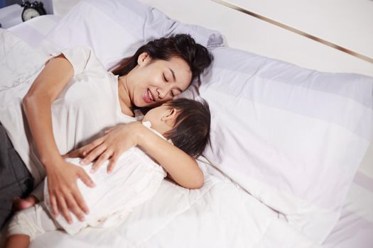 mother and baby sleeping on the bed at home