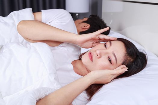 woman having sleepless on bed and having migraine,stress, insomnia, hangover in the bedroom