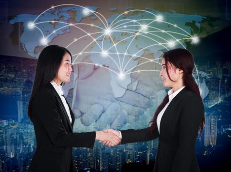 two happy young businesswomen shaking hands in her  meeting