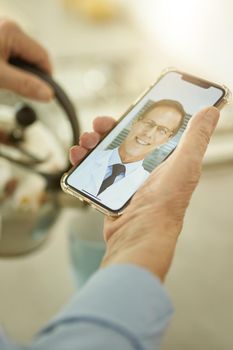 Fragment photo of man with smartphone in hand making a video-call with is healthcare consultant