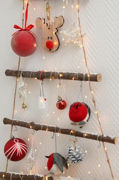 Handmade wooden Christmas tree with toys hanging on the wall