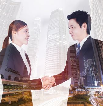 double exposure of shaking hand between businessman and businesswoman with a city background 