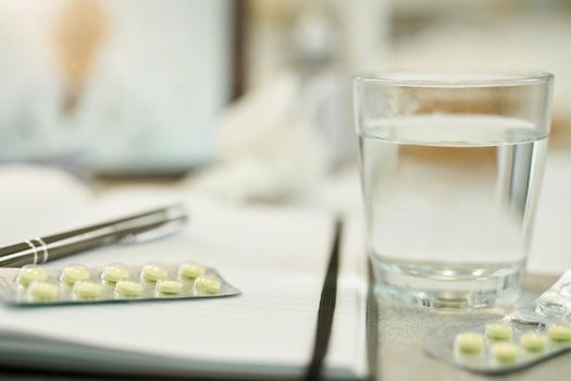 No people photo of a glass of water and blister of pills sitting on the table