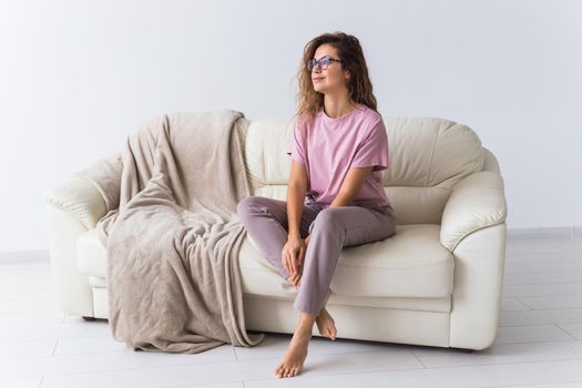 Young attractive woman dressed in beautiful colorful pajama posing as a model in her living room. Comfortable sleepwear, home relaxation and female fashion concept