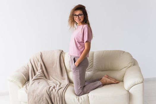 Young attractive woman dressed in beautiful colorful pajama posing as a model in her living room. Comfortable sleepwear, home relaxation and female fashion concept