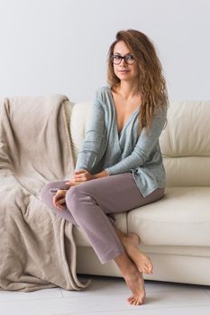 Young attractive woman dressed in beautiful colorful pajama posing as a model in her living room. Comfortable sleepwear, home relaxation and female fashion concept