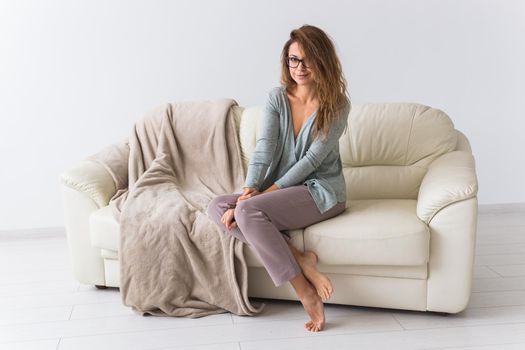 Young attractive woman dressed in beautiful colorful pajama posing as a model in her living room. Comfortable sleepwear, home relaxation and female fashion concept