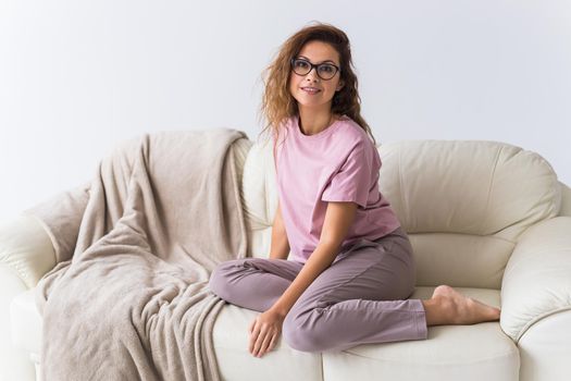 Young attractive woman dressed in beautiful colorful pajama posing as a model in her living room. Comfortable sleepwear, home relaxation and female fashion concept