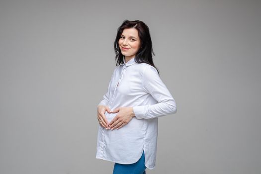 picture of a cheerful caucasian woman with black hair and pretty smile in white shirt and blue jeans posing for the camera