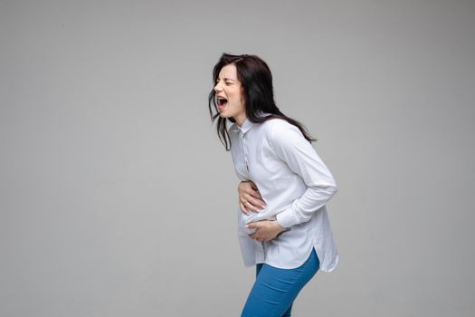 young caucasian pregnant female with dark hair screaming and giving birth to a baby