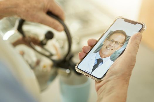 Cropped photo of person making tea while talking to healthcare professional via a video-call