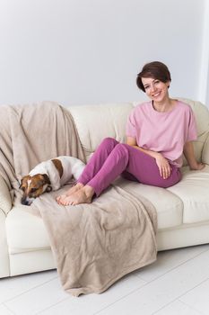 Young attractive woman dressed in beautiful colorful pajama posing as a model in her living room. Comfortable sleepwear, home relaxation and female fashion concept