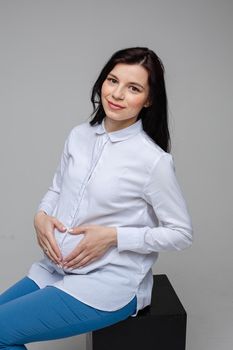 picture of a cheerful caucasian woman with black hair and pretty smile in white shirt and blue jeans posing for the camera