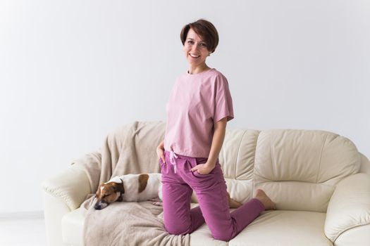 Young attractive woman dressed in beautiful colorful pajama posing as a model in her living room. Comfortable sleepwear, home relaxation and female fashion concept