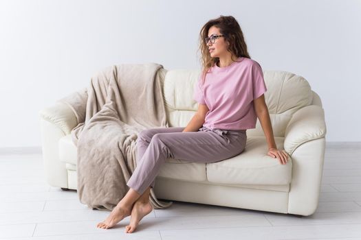 Young attractive woman dressed in beautiful colorful pajama posing as a model in her living room. Comfortable sleepwear, home relaxation and female fashion concept