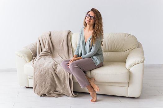 Young attractive woman dressed in beautiful colorful pajama posing as a model in her living room. Comfortable sleepwear, home relaxation and female fashion concept