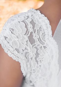 Part of the wedding dress on the bride s shoulder, close-up.