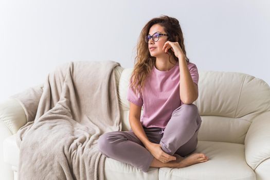 Young attractive woman dressed in beautiful colorful pajama posing as a model in her living room. Comfortable sleepwear, home relaxation and female fashion concept