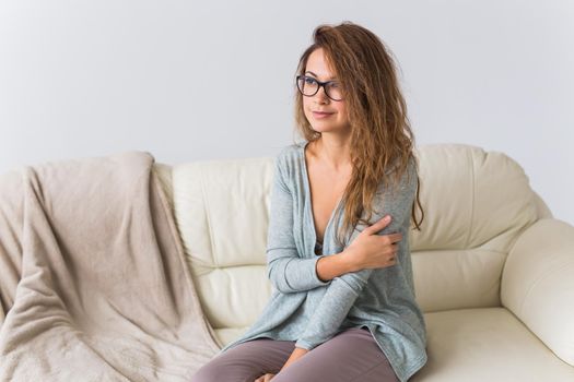 Young attractive woman dressed in beautiful colorful pajama posing as a model in her living room. Comfortable sleepwear, home relaxation and female fashion concept