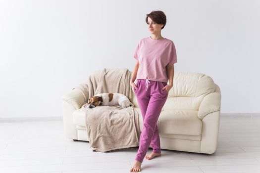 Young attractive woman dressed in beautiful colorful pajama posing as a model in her living room. Comfortable sleepwear, home relaxation and female fashion concept