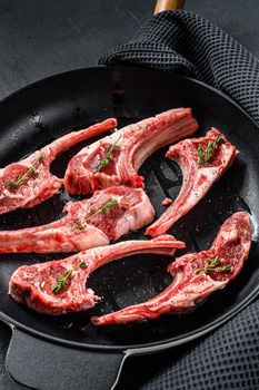 Rack of lamb , raw meat with bone. Organic lamb meat. Black background. Top view.