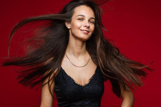 Portrait of happy pretty lady with hair motion, isolated on red background. Party concept. Copy space