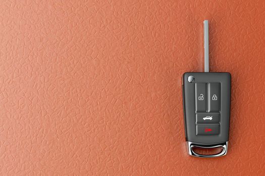 Modern car key on orange colored leather seat, top view