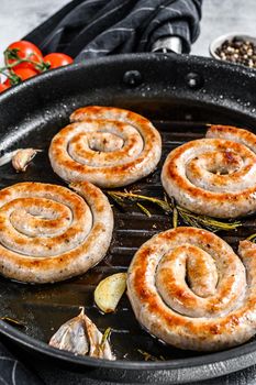 Homemade Spiral grilled sausage with spices and herbs. Gray background. Top view.