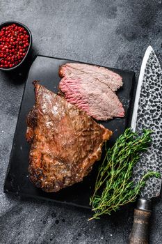 Roast beef tri tip steak bbq. Black background. Top view.