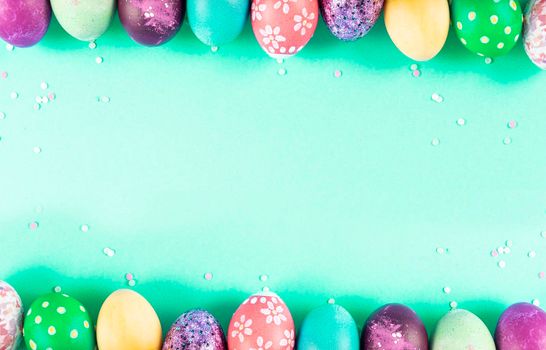 Colorful background with Easter eggs on green background. Happy Easter concept. Can be used as poster, background, holiday card. Flat lay, top view, copy space.