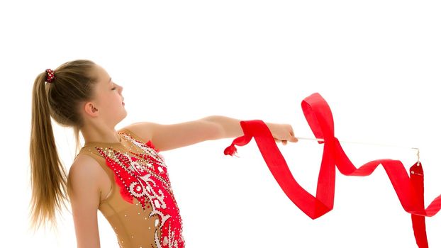 Little girl gymnast performs exercises with tape. The concept of sport, competition. Isolated on white background.