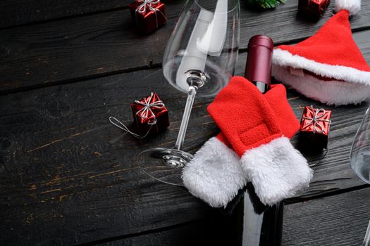 Decorative Christmas table with wine bottle, on black wooden table background, with copy space for text